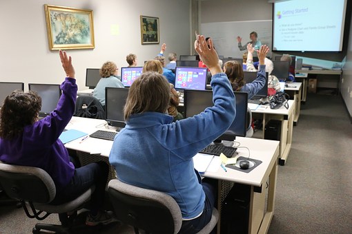 people rising hands in class